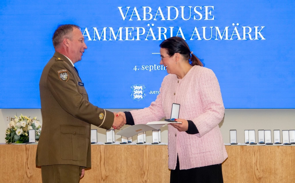 Justiits- ja digiminister Liisa-Ly Pakosta annab Elari Hiisile üle Vabaduse Tammepärja aumärgi.